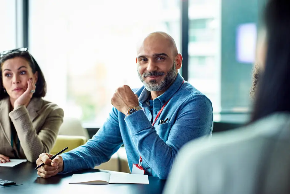 Employee taking part in a leadership development session, listening to an expert speaking.